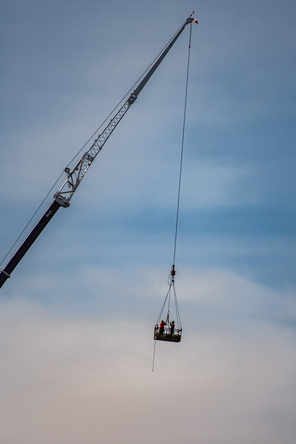 Guys in crane bucket photo